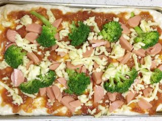 10、改良版火腿披萨,先撒一层芝士，放上火腿肠片和西兰花，再次撒一层芝士碎。