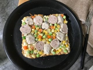 7、牛肉丸吐司披萨,再摆上各种蔬菜粒（我用的是胡萝卜粒、豌豆粒、玉米粒）。