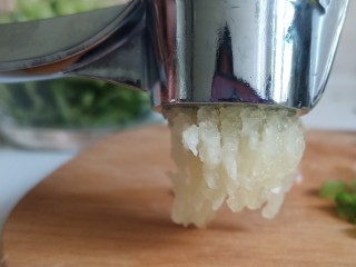 5、手撕鸡胸肉,用力一下压出蒜泥，大蒜经过挤压才会释放大蒜素，味道也更好