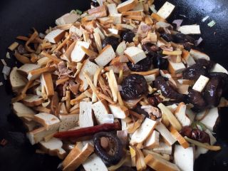 13、海鲜卤面,随后先放入香干片煸炒，把香干的豆腥味煸炒出去，然后放入香菇、干花菜、笋干，煸炒片刻。