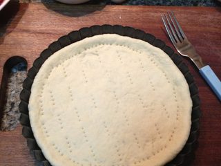 9、肉香满溢披萨,取出烤盘,会发现面皮稍稍鼓起,用叉子在面皮上戳洞(如图)