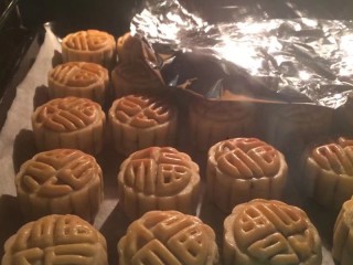 29、金秋玫瑰五仁月饼,一共烤20分钟,中途每隔五分钟取出刷一遍蛋黄液,我家烤箱红外烤有点不均匀,所以颜色深的区域我用锡纸盖一下,让颜色浅的月饼继续上色,微黄上色就可以,不可烤太久