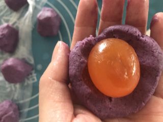 4、抹茶紫薯蛋黄酥,紫薯泥分成22克一个8个，然后包进蛋黄，我是买的整个的咸鸭蛋自己抠出来的蛋黄，蛋黄放烤箱稍微烤一下，表皮干了就行，不然滑滑的不好包