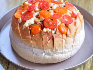 8、披萨派对面包,表面撒上玉米粒、切片的小蕃茄,并且挤上沙拉酱。