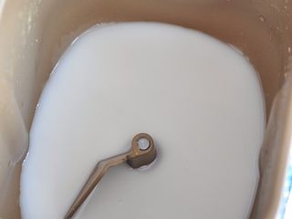 1、披萨派对面包,将面包桶中放入椰浆、糖、盐。