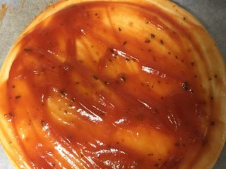 4、海鲜披萨,将披萨酱涂在饼上。