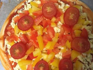 6、海鲜披萨,再把彩椒和圣女果铺上
