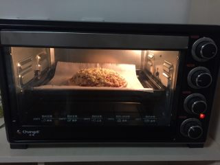 9、海鲜披萨,这时烤箱调到上下200度预热，将披萨放在油纸上入烤箱，加热20分钟，这期间可以观看到它慢慢变成披萨美丽的样子！