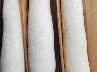 10、当主食一次可以吃三个的法棍面包,盖上湿布再次放入烤箱发酵半小时。用油纸间隔开，这样发酵的时候基本形状不会变。