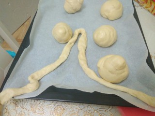 7、迷你巨无霸汉堡包～汉堡胚制作～,拿一块面一边捏一边搓，做成长条形。这个过程就把气体都排出来了。