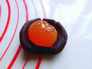 11、豆沙蛋黄月饼,取一块豆沙馅,将蛋黄包起来。我的月饼磨具是50g的,所有我的月饼馅是30g,月饼皮是20g。