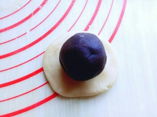 14、豆沙蛋黄月饼,取一个小面团,用手掌心压扁,再把馅料放在面皮上。