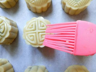 18、豆沙蛋黄月饼,烤箱预热: 上下火190度,预热5分钟。做好的月饼,入烤箱前,首先喷上一层清水。