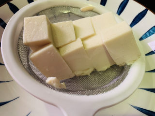 3、小葱拌豆腐,装漏勺中
