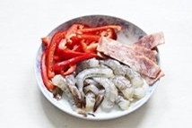 2、薄底鲜虾培根披萨,甜红椒洗净切丝，培根切小块，鲜虾洗净去壳去头，抽去虾线备用