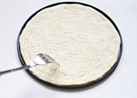 3、薄底鲜虾培根披萨,发酵好的面团取出，擀成所需的薄片，如图用的是八寸活底模，大约这个份量两人食