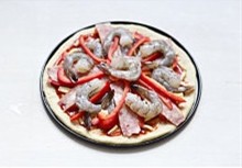 6、薄底鲜虾培根披萨,再次摆入剩余红椒丝，鲜虾仁于表面，同样磨入黑胡椒和海盐适量（随个人口味）