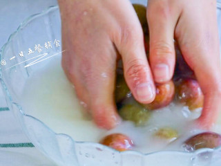 2、西梅汁,西梅放水中,倒入淀粉,静置10分钟,将西梅搓掉白霜,减轻青涩的味道。