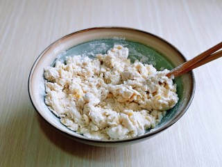 2、培根火腿披萨,分次加入温水，水量自己掌握，一边加水，一边用筷子搅拌至絮状且无干粉即可。