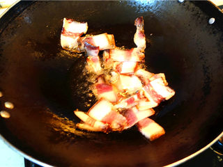 6、蒜苗炒腊肉,放入腊肉翻炒。