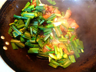 10、蒜苗炒腊肉,放入蒜苗叶子，翻炒几下，放入适量鸡精。