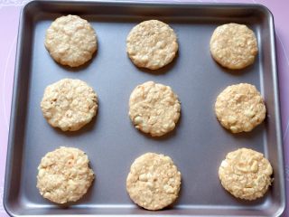 11、花生燕麦饼干,手上沾湿后，取一小块燕麦团搓成圆球状，然后压扁，摆放在不粘烤盘中，如果不是不粘烤盘，记得要垫油纸哦。