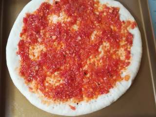 22、海鲜披萨10寸,现在开始组装披萨，披萨皮均匀的涂上披萨酱，边缘1-2cm的地方不需要涂上