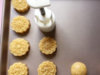 12、花生酥～#家有烤箱#,拿模具用力均匀地压出花形，模具不用擦油，面团本身就蛮油的了。（我用的是50g的月饼模，你也可以用饼干模压成型，或者直接揉成圆形，这个就随你喜欢啦）