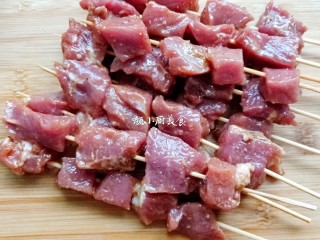 6、烤肉串,肉串全部穿好后,烤盘内放入一张锡纸,把穿好的肉串放入烤盘内。