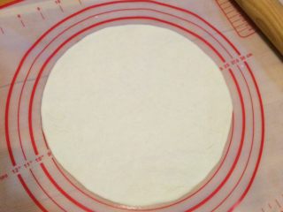 5、培根口蘑田园披萨,把面团用擀面杖擀成9寸大的面饼。