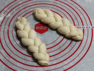 11、香葱辫子包,编好后把两头捏紧，如果面团太干就会散开，盖上保鲜膜醒发到1.5倍大