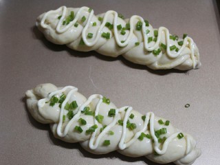 12、香葱辫子包,刷上一层鸡蛋液，挤上沙拉酱，撒上香葱碎。有芝士的可以撒上马苏里拉芝士。