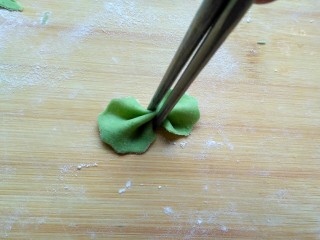 11、菠菜蝴蝶面,用筷子在中间夹一下,不要太使劲会夹断。剩下的边边角角在揉成面团擀成薄饼,重复上述步骤,做成蝴蝶面……