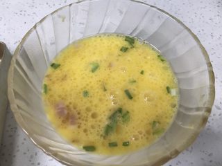 14、堡尔美克鸡蛋披萨杯,15、取一半培根和香葱放入鸡蛋液中，撒1g盐。搅拌均匀。