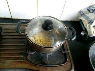 3、自创【煎酿土司披萨】,把玉米放进锅里闷煮一下。