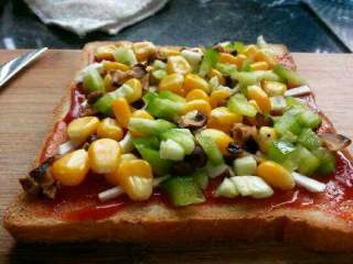 9、自创【煎酿土司披萨】,撒上玉米，青椒香菇。