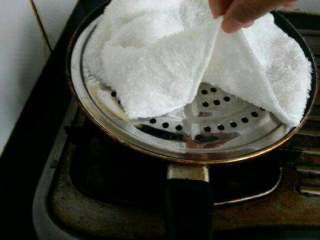 12、自创【煎酿土司披萨】,用有孔的盖子盖上毛巾闷一下，开小火这样不会糊（这样闷着有水份的），1～2分钟就可以了。