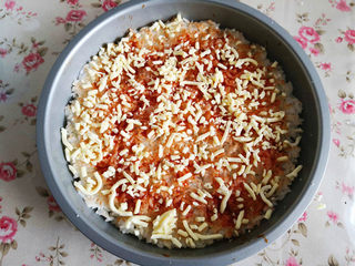 3、大米披萨,取一部分马苏里拉芝士撒上刷了番茄酱的米饭上,大约70克左右,