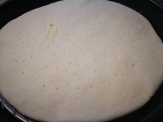 7、做饼＋蘑菇鲜虾披萨饼,披萨面坯擀好放入烤盘 用牙签扎出小孔