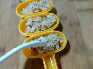 4、五分钟的早餐——香松饭团,把拌好的香松米饭舀入模具中，量大概是和一面的模具高度持平。