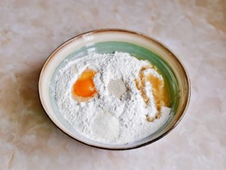 1、虾仁培根披萨,首先将面粉放入大口器具中，中间挖个坑加入酵母，旁边加入玉米油，白砂糖，鸡蛋，搅拌均匀，再分次加入温水，搅拌成絮状。