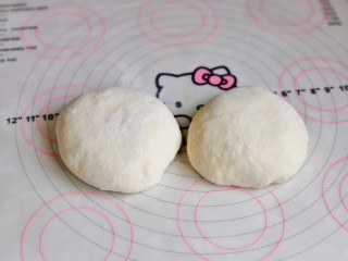 5、虾仁培根披萨,发酵好的面团，分两等份揉圆，盖上保鲜膜醒10分钟。