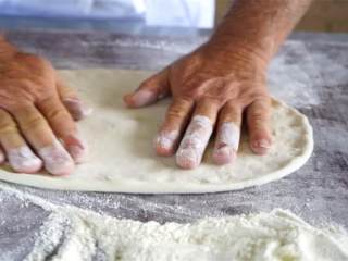 6、卡布里乔莎披萨,把披萨揭下来，放到烤盘上，再用手掌按压一次。