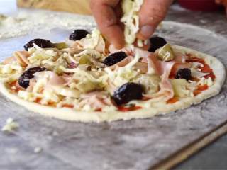 10、卡布里乔莎披萨,现在，在披萨上放上洋蓟 ，火腿片 ，黑橄榄 ，蘑菇（切片） (2 个) ，水牛马苏里拉芝士（刨碎或切丁） 。