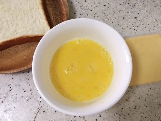 4、创意培根鲜虾鸡蛋三明治,step3:取一颗鸡蛋打散，加入少许盐和少许水