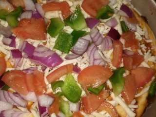 13、牛肉蔬菜披萨,铺上西红柿，青椒和洋葱丁，撒适量披萨草