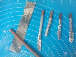 5、爱心夹心挞饼,面团冷藏期间制作饼干的小手柄，锡纸分割成小片，包住百醇（防止烤糊），包好后一分为二。