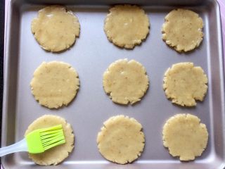 12、核桃酥～#中式点心#,用刷子给核桃酥刷上蛋液。（刷表面的蛋液，我是用刚刚留下的蛋黄液加少许玉米油搅匀的，你也可以用全蛋液。）