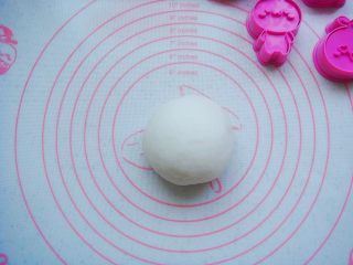 5、卡通冰皮月饼,放在垫子上趁热揉成光滑的面团。