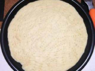 2、芝士榴莲披萨,用叉子叉出均匀的小孔,烤箱预热200度，烤5分钟定型